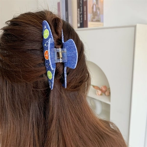 Dettaglio della pinza per capelli in acetato blu con stampa limone per acconciature
