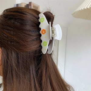 Dettaglio della pinza per capelli con motivi al limone e strass sull'acconciatura