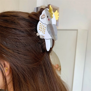 Detailed close-up of a white cockatoo acetate hair claw clip worn on a half-up hairstyle