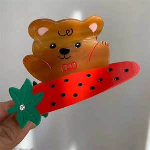 Vue détaillée d'une pince à cheveux en acétate avec un ours et des motifs de fruits