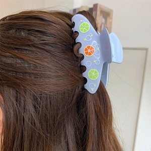 Dettaglio di un fermaglio per capelli blu con fette di limone e piccoli strass lucidi