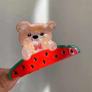 Détail de la pince à cheveux ours marbré et pastèque en acétate au fini brillant