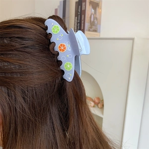 Vista dettagliata di una pinza per capelli lavanda con motivi di limone su capelli castani