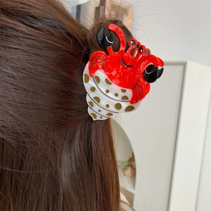 Pince à cheveux crabe ermite à pois créative présentée dans une coiffure pratique