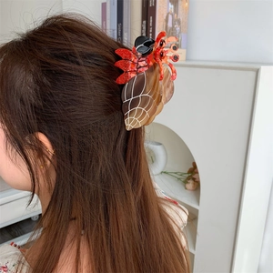 Detailansicht einer großen Haarspange in Einsiedlerkrebs-Optik getragen bei einer Hochsteckfrisur