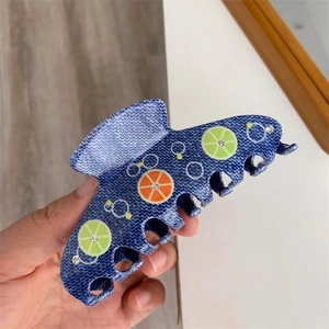 Dettaglio del fermaglio per capelli stampa denim blu con agrumi e piccoli strass lucidi