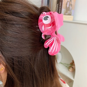 Pince à cheveux poisson rouge rose avec texture marbrée portée sur cheveux brun foncé