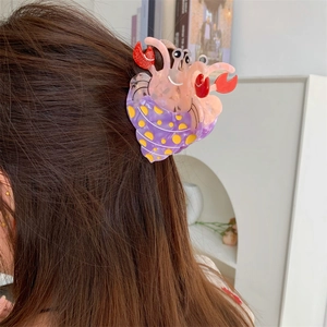 Vue détaillée d'une pince à cheveux créative en forme de bernard-l'ermite rose à pois jaunes