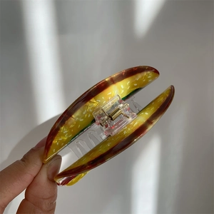 Detail view of the layered acrylic hamburger hair claw clip with golden metal spring