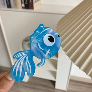 Détail de la pince à cheveux en acétate bleu marbré en forme de poisson rouge mignon