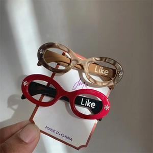 Detail showing red and marble acetate glasses-shaped hair clips with 'Like' lettering