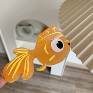 Détail d'une mignonne pince à cheveux poisson rouge orange avec de grands yeux