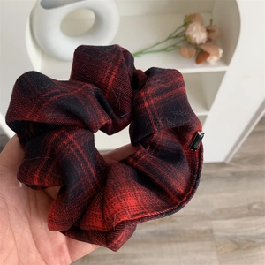 Classic red and black plaid scrunchie with soft autumn texture and black accent detail