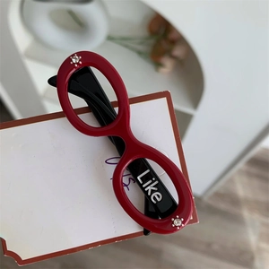 Detail of red and black acetate glasses hair clip with Like letter and tiny rhinestones