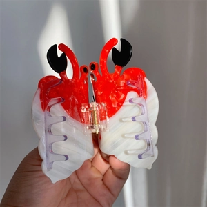 Détail d'une pince à cheveux crabe créative en acétate rouge et noir élégante