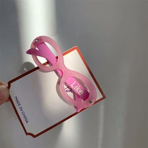 Close-up of pink glitter glasses hair clip with Like text and rhinestone detail