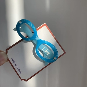 Macro shot of blue marble pattern acetate eyewear hair clip with Like text and rhinestones