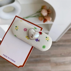 Barrette à cheveux fleurie avec breloque cœur perlé et cristal sur carte