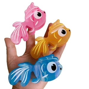 Trois pinces à cheveux poisson rouge colorées en rose, orange et bleu en acétate