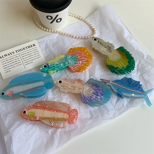 Dettaglio di fermagli per capelli creativi a forma di pesce in acetato con motivi marmorei