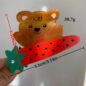 Brown acetate bear hair claw clip with carrot detail and red bow decoration, 9.5cm length