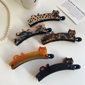 Detail shot of five cat-shaped acetate banana hair clips in leopard and marble patterns