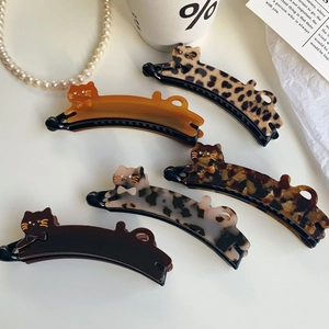 Close-up of cat-shaped acetate hair clips in leopard print and amber tortoise shell