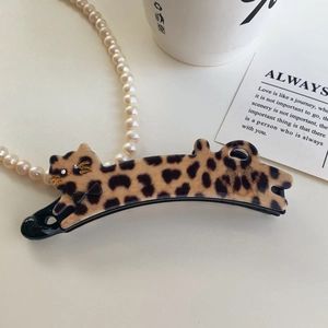 Detail of leopard print cat-shaped banana clip with rhinestone eyes and bow detail