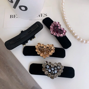 Dettaglio di fermagli per capelli a cuore in velluto con strass brillanti e clip a becco