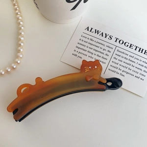 Macro detail of amber cat banana clip showing quality acetate texture and rhinestone eyes