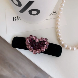Elegante fermaglio per capelli in velluto con strass a cuore rosa su sfondo bianco