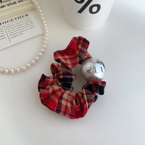 Vue détaillée du chouchou à carreaux rouge et noir avec pendentif lettre et perles élégantes