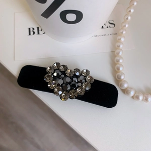Dettaglio del fermaglio per capelli a cuore in velluto con strass su sfondo elegante
