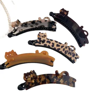 Five leopard print and tortoiseshell cat-shaped acetate banana hair clips with rhinestones