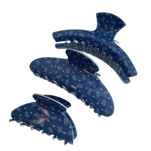 Three-piece set of navy blue acetate hair claws with white star and heart patterns