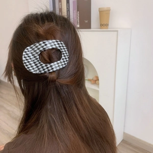 Classic black and white houndstooth hair claw clip styled on long brown hair back view