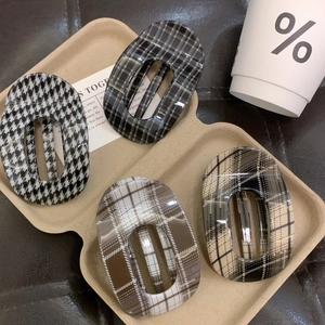 Elegant plaid hair claws in checkered patterns displayed on eco-friendly paper tray