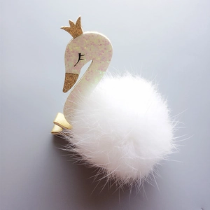 Barrette cygne rose avec pompon blanc et couronne dorée sur fond gris épuré