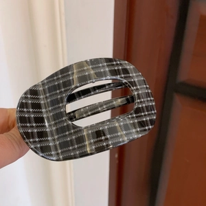 Detail of classic black and white plaid hair clip with hollow rectangular design