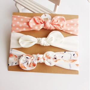 Three-piece set of cotton baby headbands with bowknots on brown cardboard packaging
