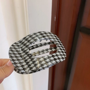 Detailed view of the black and white houndstooth hair claw clip with smooth glossy finish