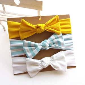 Set of 3 soft cotton baby bow headbands in yellow, striped, and white on display card