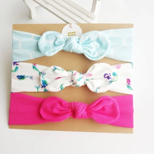 Three-pack of soft cotton elastic baby headbands with assorted patterns on a card