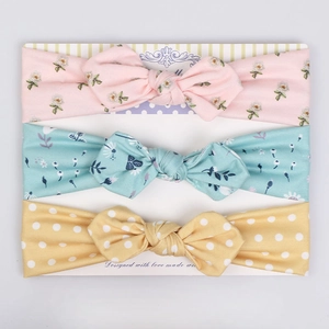Three-piece baby floral and polka dot elastic headband set on display card