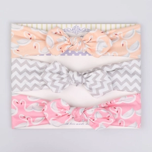 Three-pack baby elastic headbands with swan print and bows on cardboard display