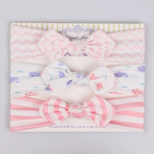 Detailed view of three-piece baby bow headband set with whale and stripe patterns