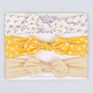 Detailed view of 3-piece floral and polka dot infant headbands on display card