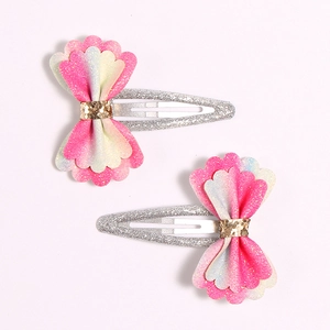 Detail of pink and white glitter hair clips with shimmering petal bow design for girls