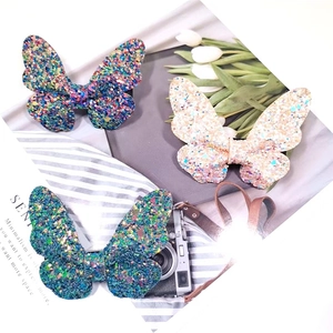 Close-up of glittery butterfly hair clips in purple, pink and green for girls