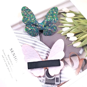 Detail view of glitter butterfly hair clips with sequin fabric and metal duckbill clamps
